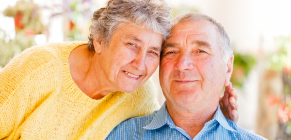 elderly couple smiling at the camera