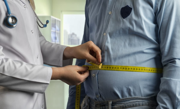 man getting his waist measurement in doctor's office
